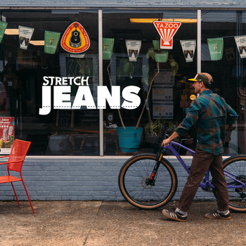 person riding a bike in dirt with super stretch jeans text overlay