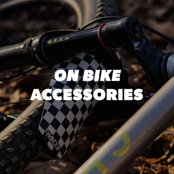 Close-up of a bike tire with checkered pattern and text 'On Bike Accessories' on a blurred natural background.