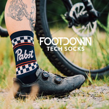 Person wearing Pabst branded socks with a bike in the background