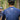 Two cyclists in a forest, one wearing a blue jersey with text on the back.