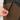 Close-up of a person adjusting a zipper on brown pants with a neutral background