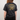 Person wearing a black t-shirt with yellow graphics and text on the back.