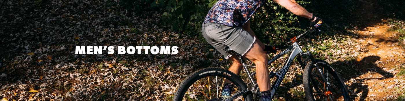 Man riding a bicycle on a trail with 'Men's Bottoms' text overlay