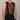 Person wearing a colorful patterned sleeveless shirt with a neutral background