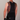 Person wearing a black sleeveless shirt with colorful geometric pattern on the back against a plain background