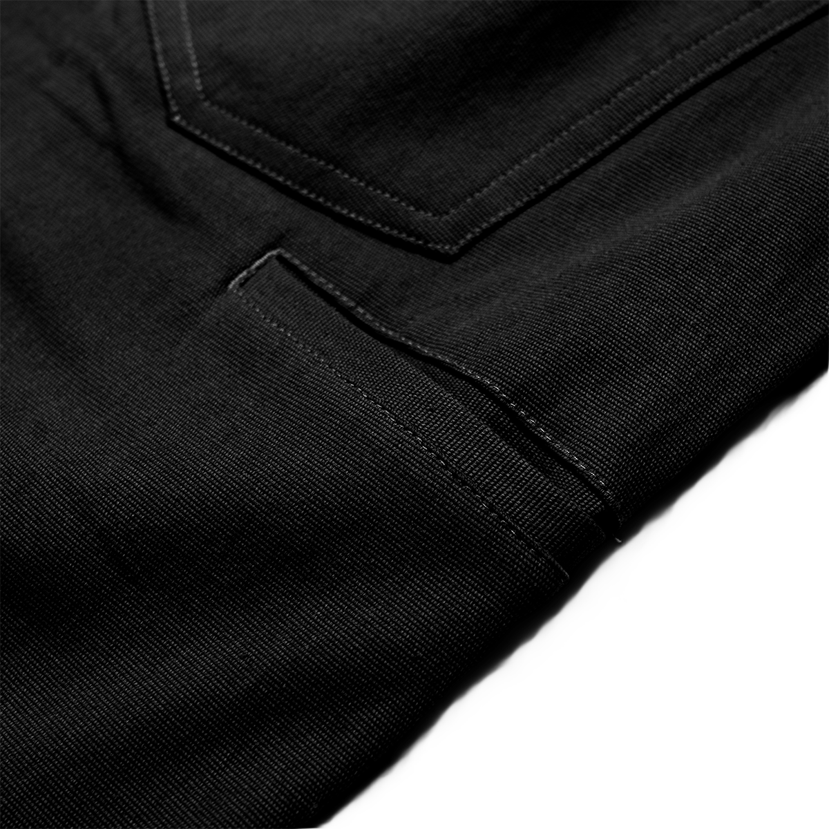 Close-up of black pants with a pocket detail on a white background