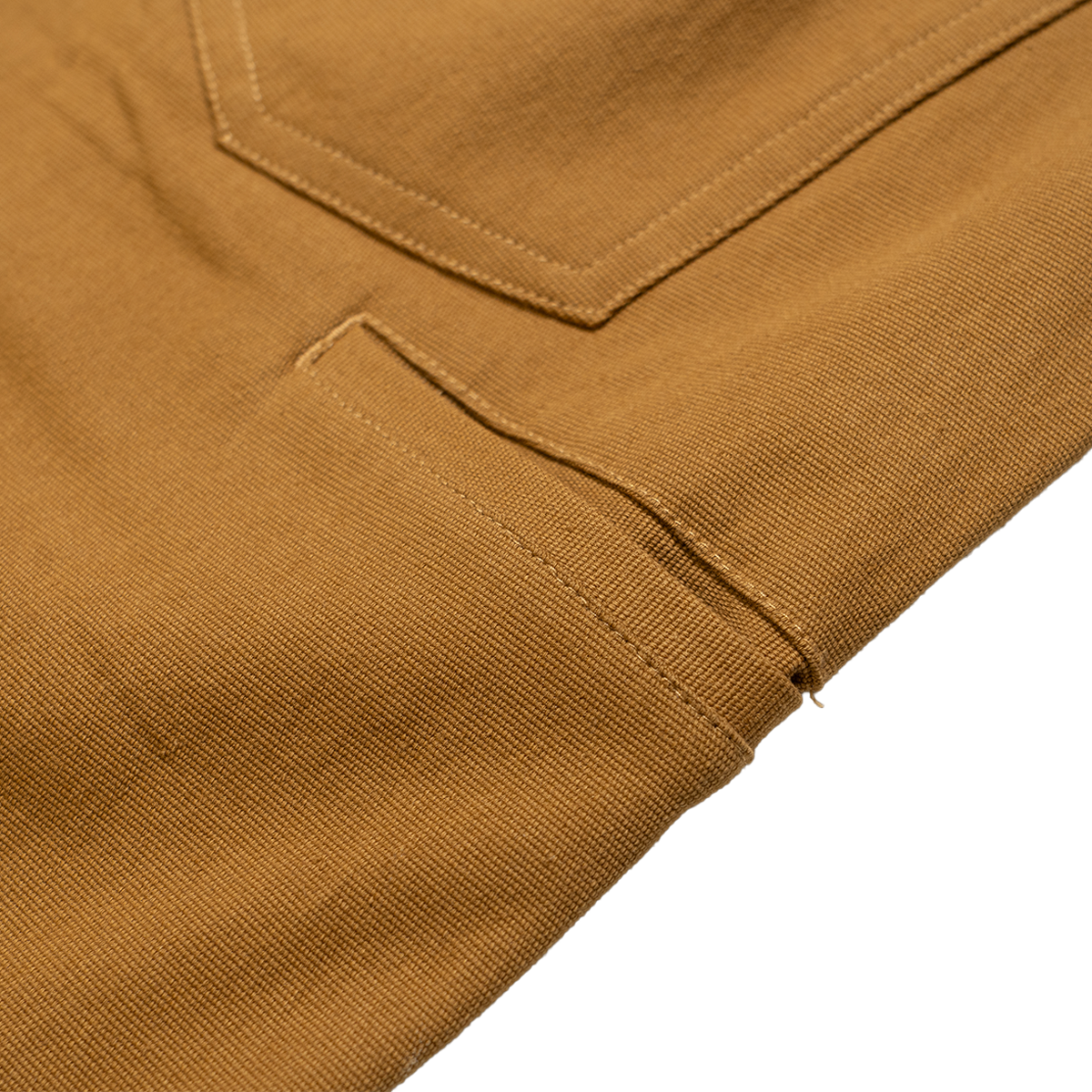Close-up of a brown fabric with a pocket detail on a white background
