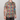 Person wearing a colorful floral patterned shirt on a plain background
