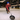 man throwing a skillet on an ice rink wearing a red hoodie and colorful gloves