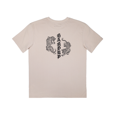 A light beige crewneck t-shirt with a black graphic on the chest depicting two stylized tigers facing each other, with the vertical text 'HAND' integrated between them.