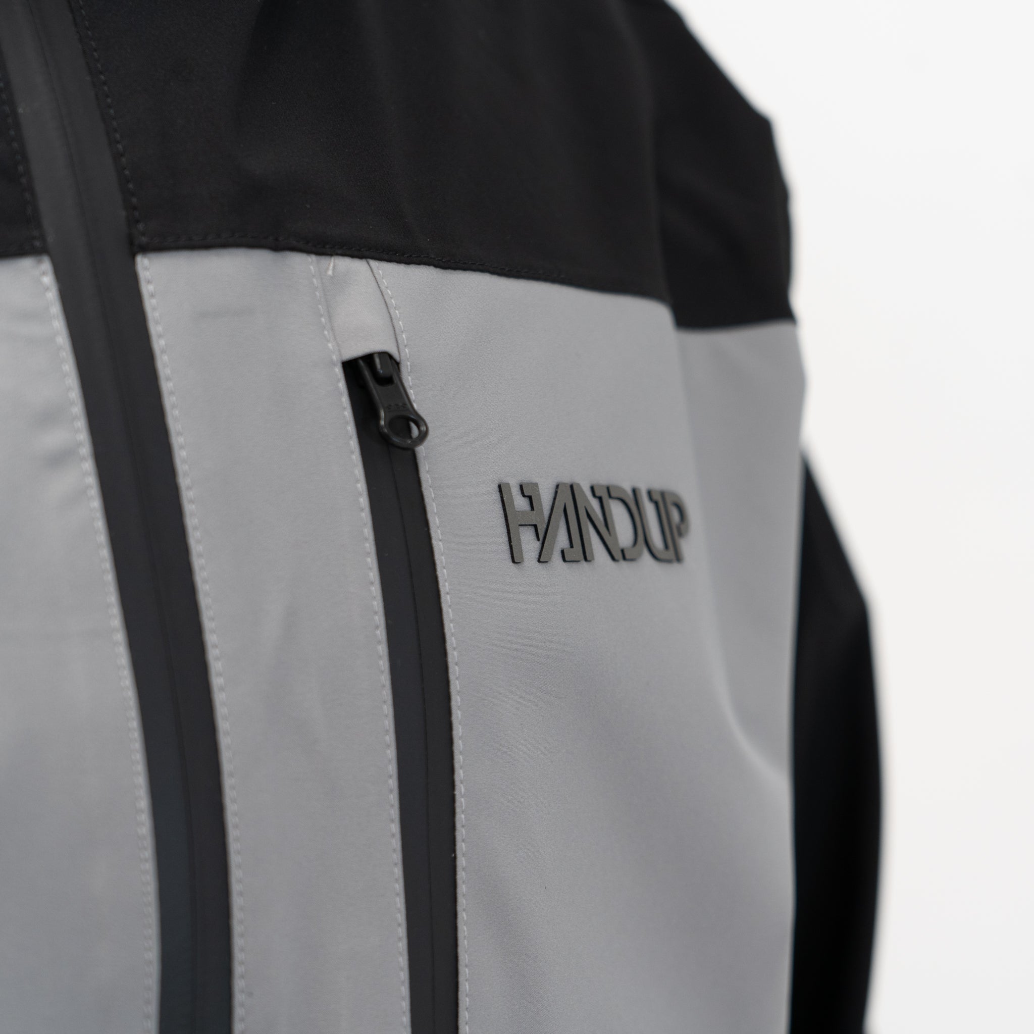 close up of the HANDUP logo on a grey and black jacket
