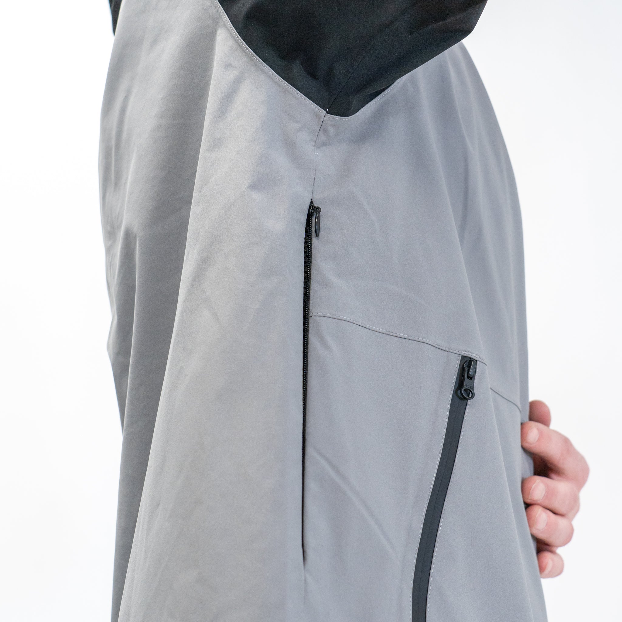 close up of a person wearing a grey and black jacket, featuring a vent under the arm