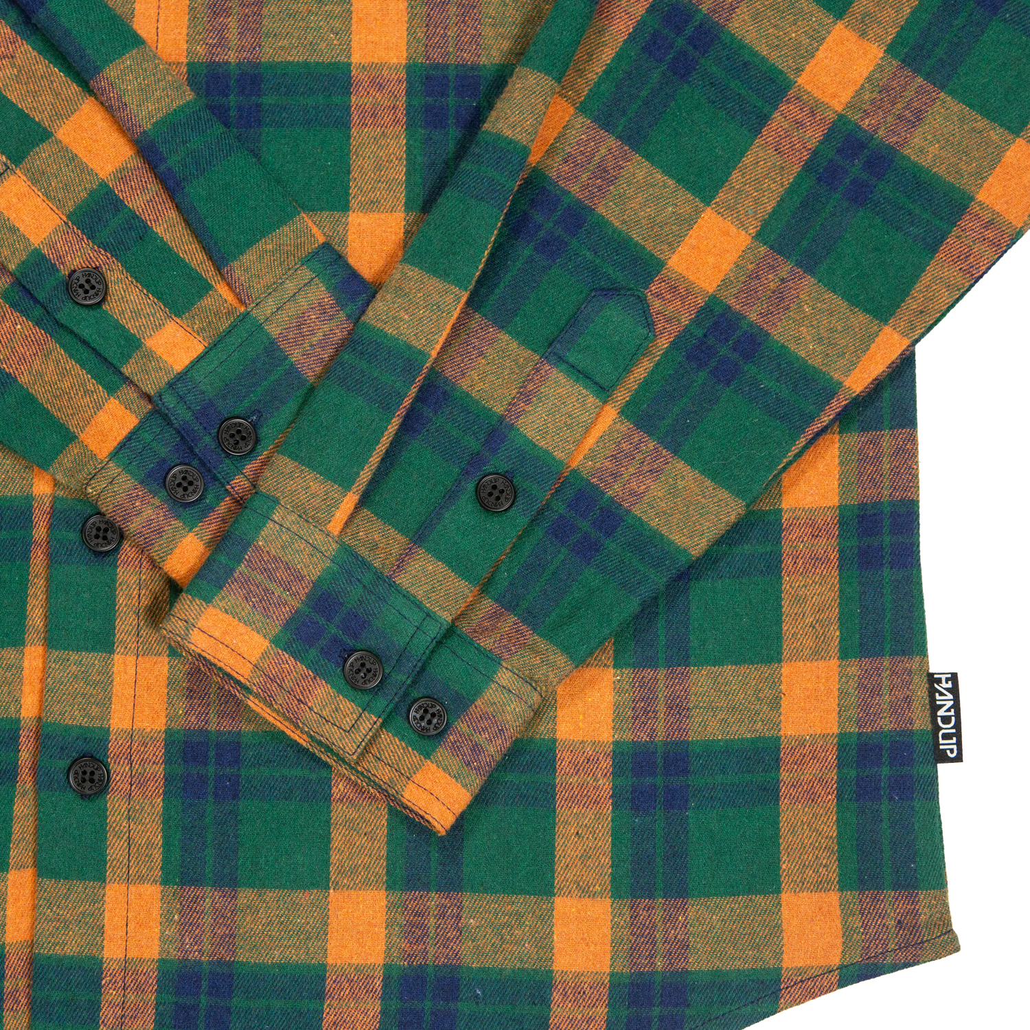 Green and orange plaid shirt with buttons on a white background