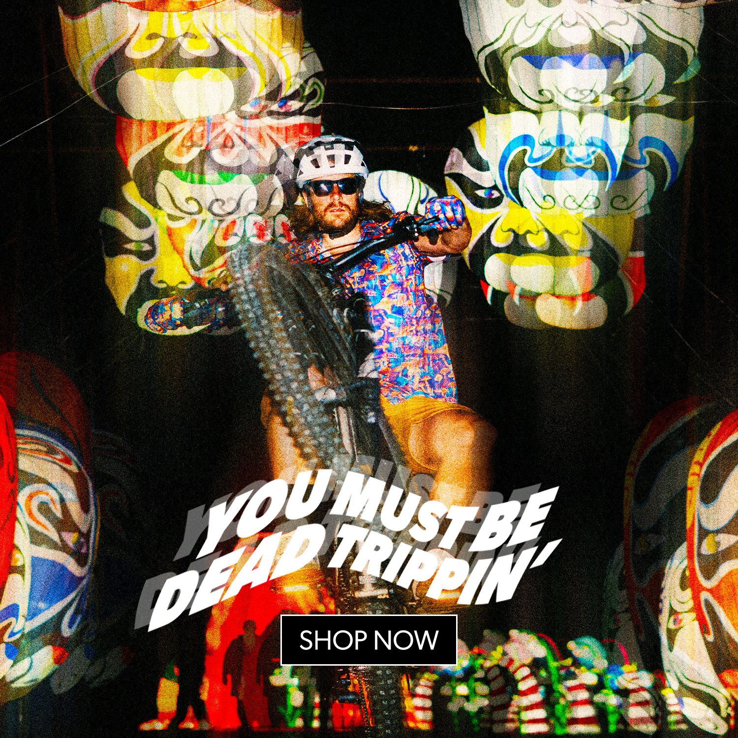 Person on a motorcycle with colorful graphics and text in the background