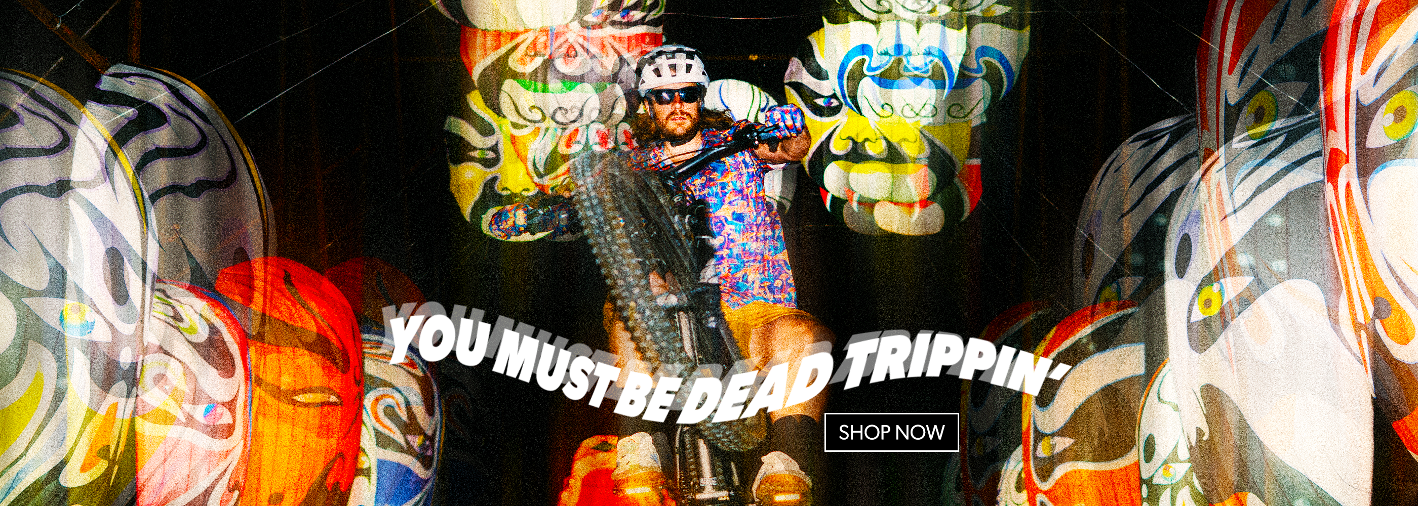 Colorful mask display with text 'You Must Be Dead Trippin'' and 'Shop Now' button.