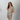Woman wearing a leopard print outfit with sunglasses on a gray background