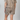Person wearing a leopard print outfit on a plain background