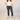 Person wearing a white t-shirt, blue jeans, and white sneakers on a plain background