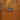 Close-up of a brown backpack with an orange topographic contour pattern and a black brand label reading HANDUP.