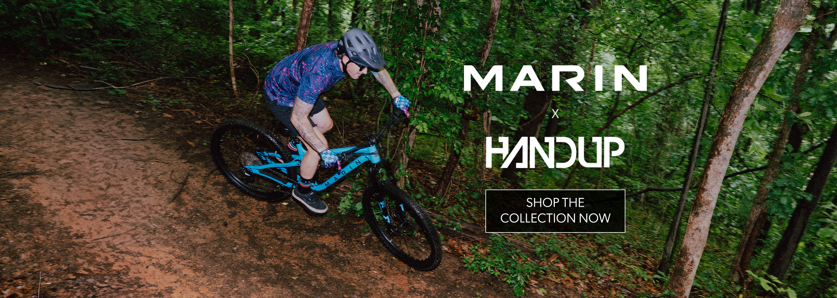 Person riding a mountain bike on a trail with 'Marin Handup' branding.
