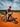 Person on a mountain bike on a red dirt track with a blue sky and clouds in the background