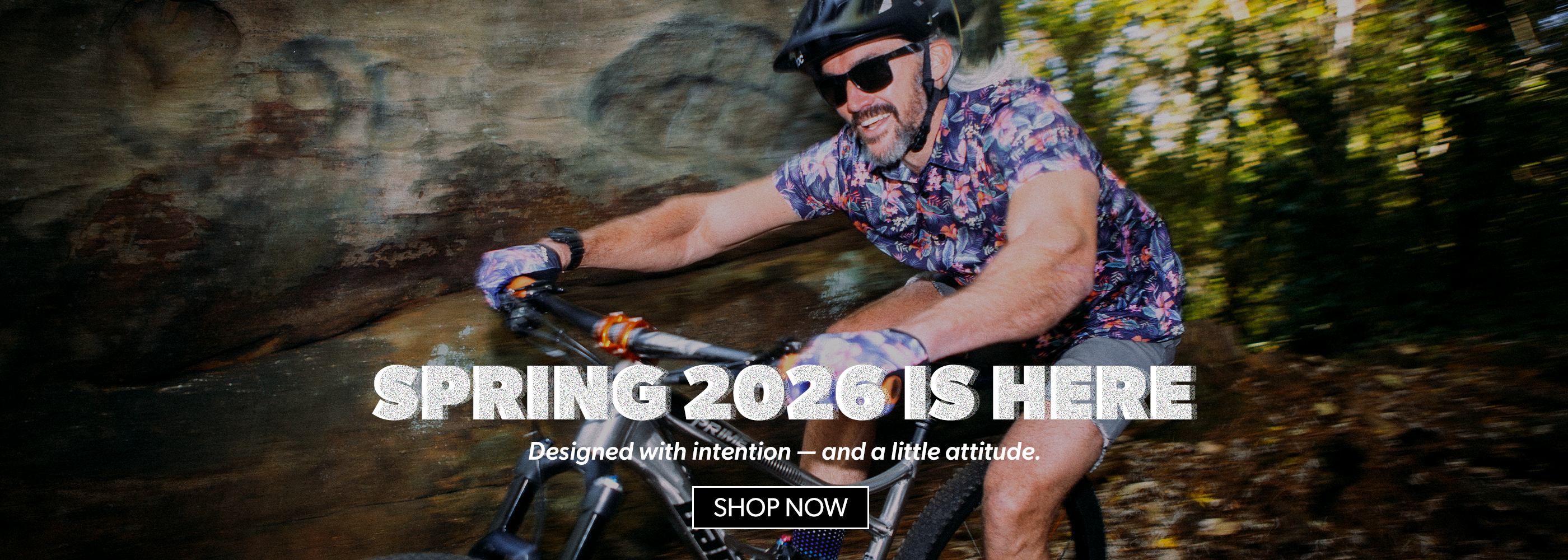 Man riding a bike with text overlay about Spring 2026 and a call to action to shop now.