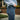 Person wearing blue jeans with a brand logo, standing outdoors.