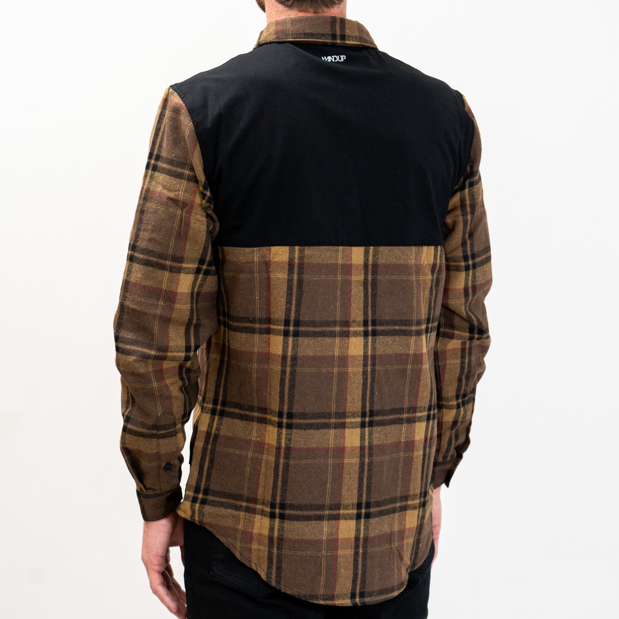A long-sleeved Flannel Button Up shirt in brown and tan plaid pattern with a solid black panel across the shoulders.
