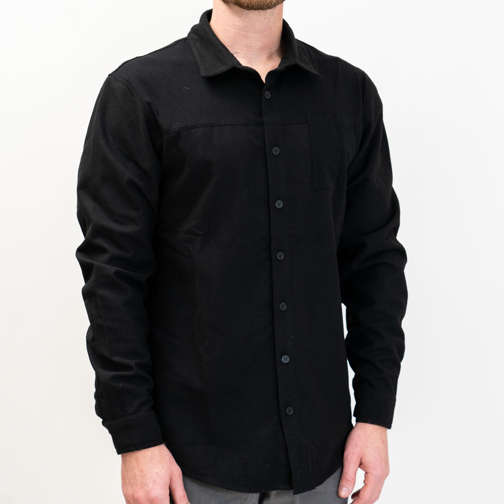 A solid black long-sleeved flannel button-up shirt.