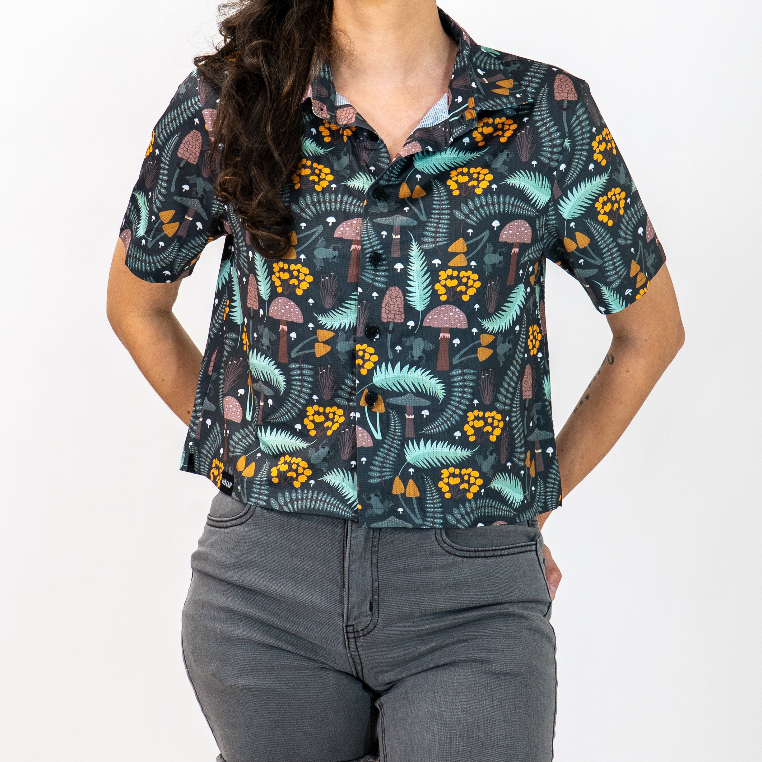 Person wearing a patterned shirt with nature-themed design on a plain background