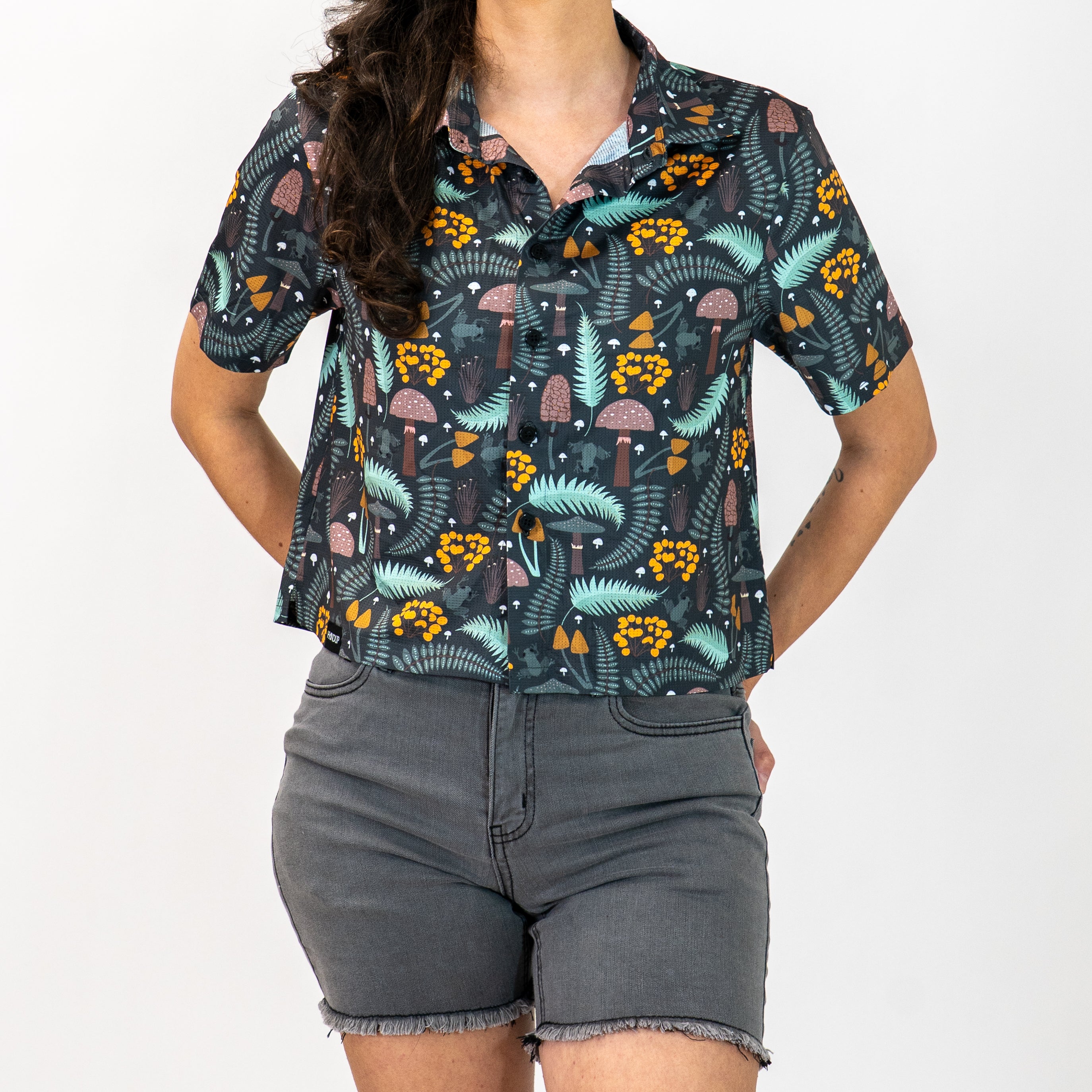 person wearing forest patterned cropped button up tech shirt