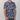 Person wearing a patterned shirt with blue, white, and red design on a plain background