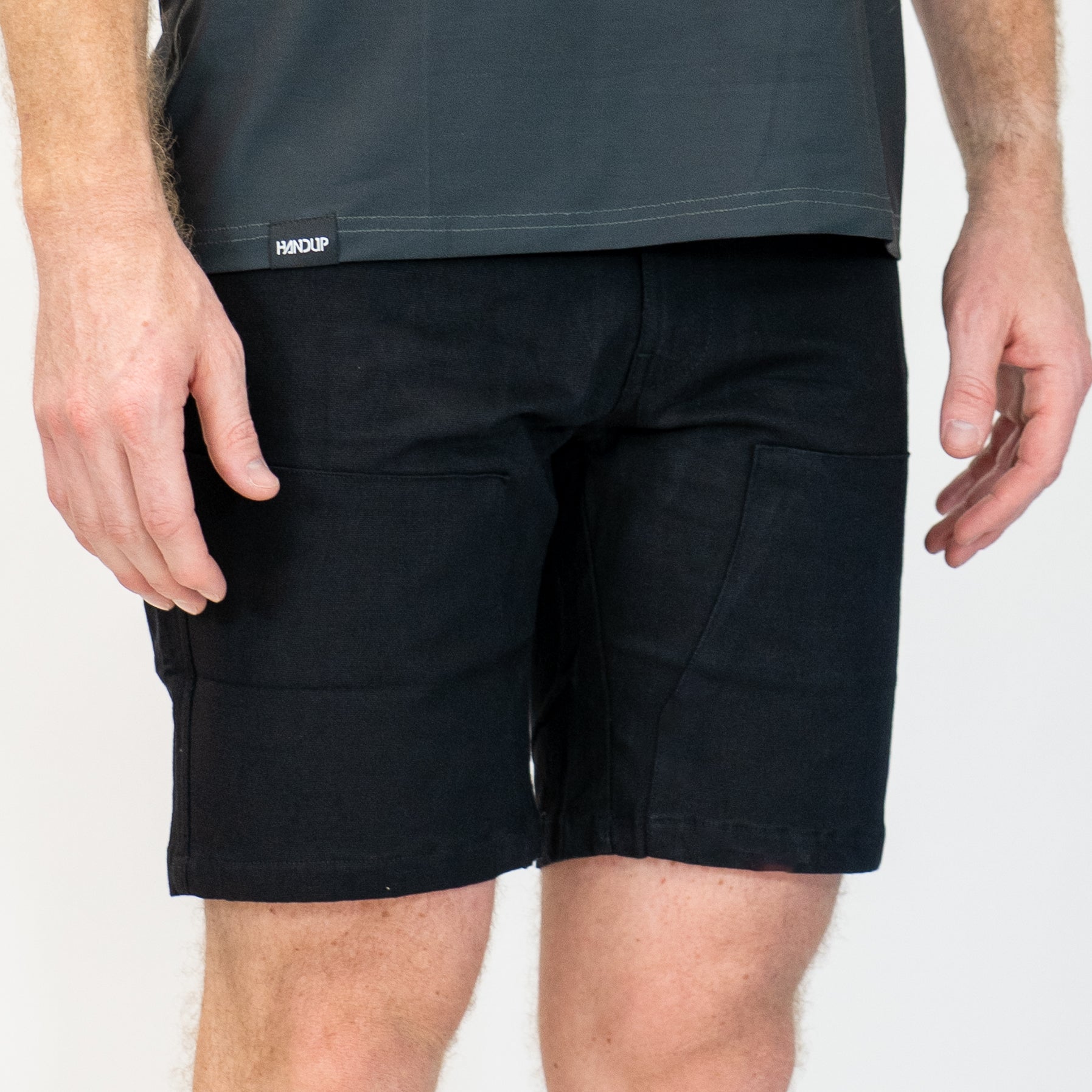 person wearing black canvas work shorts