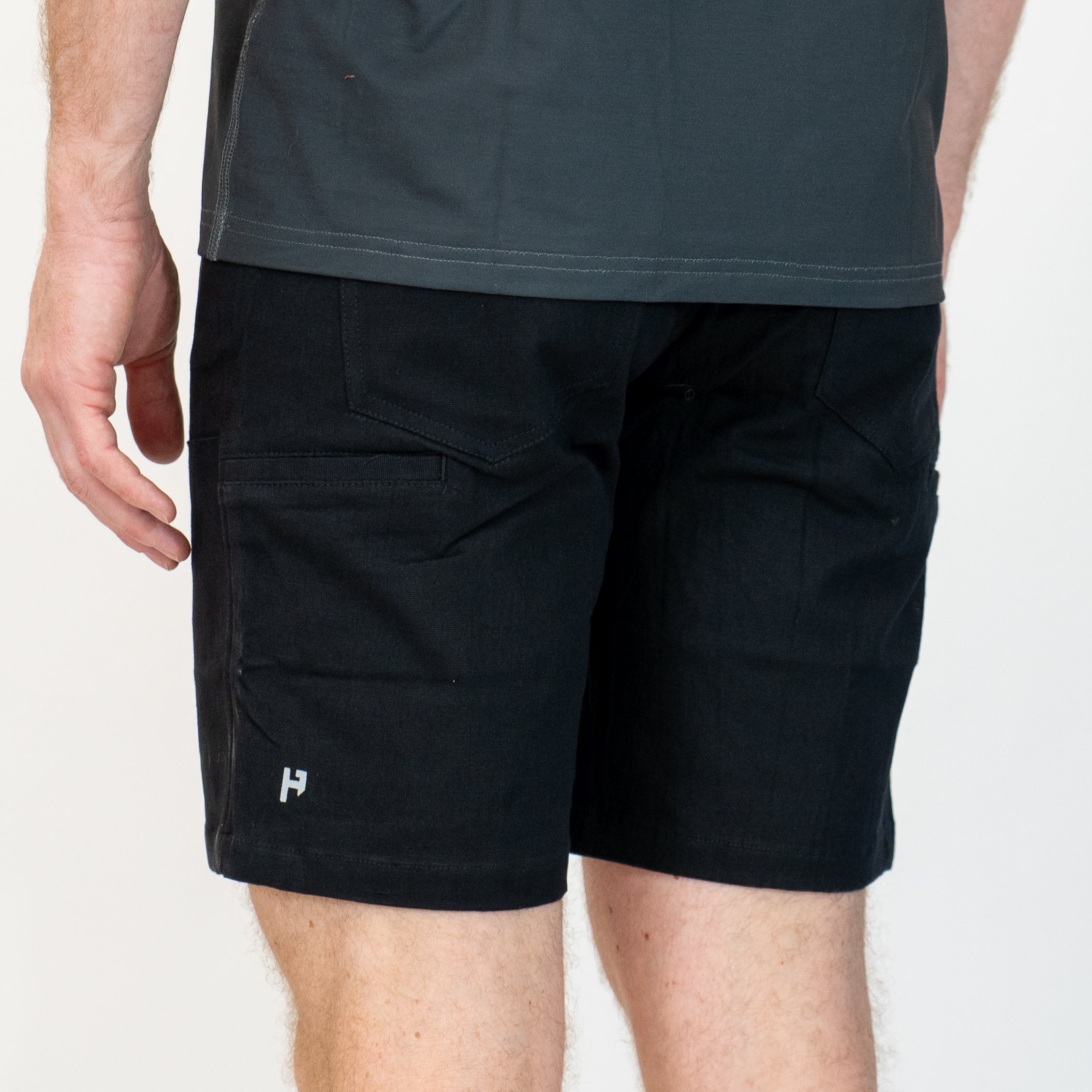 Black shorts worn by a person on a white background