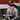I man wearing a camo shirt and black hat with 'HEADWEAR' overlayed