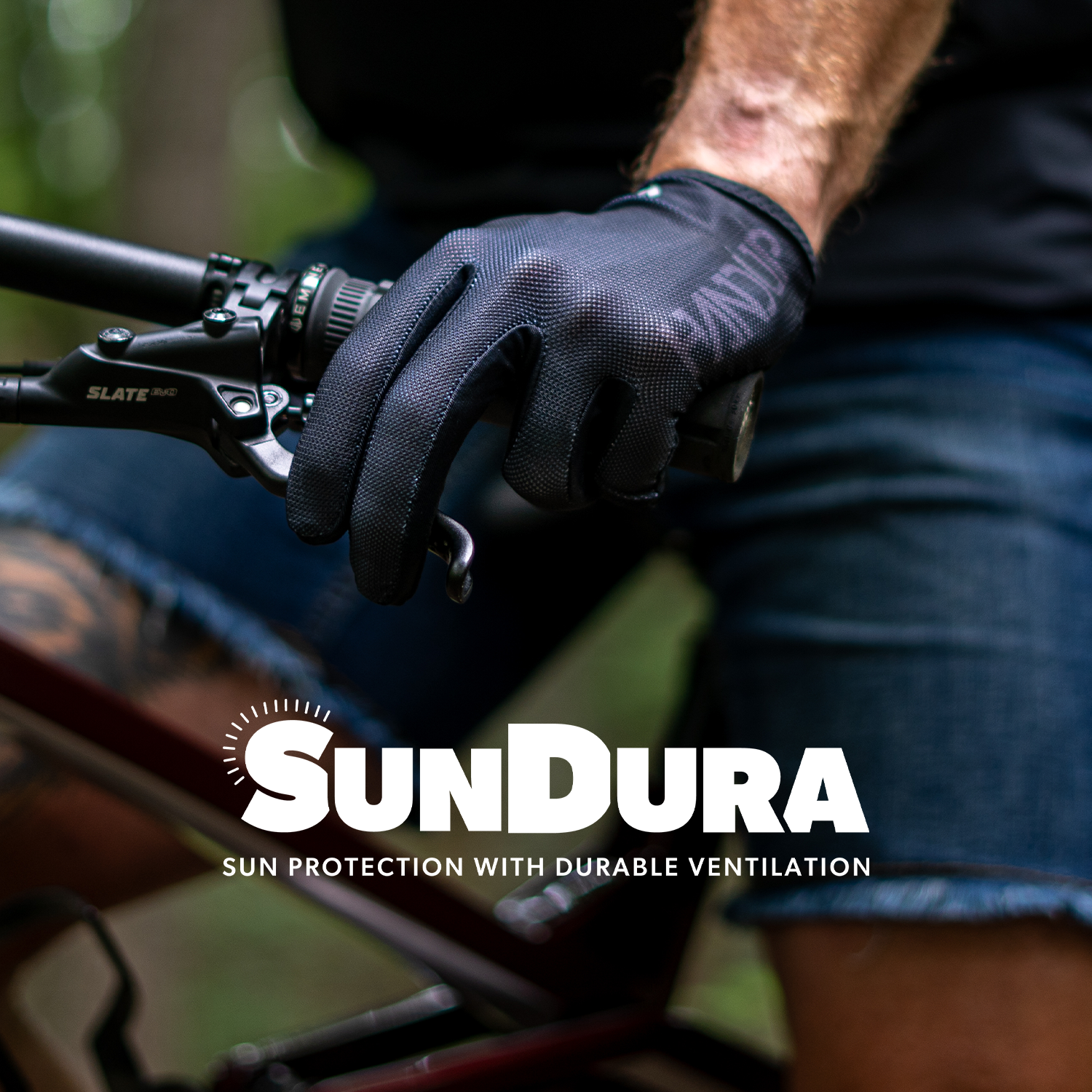 Person wearing gloves on a bicycle with Sundura branding