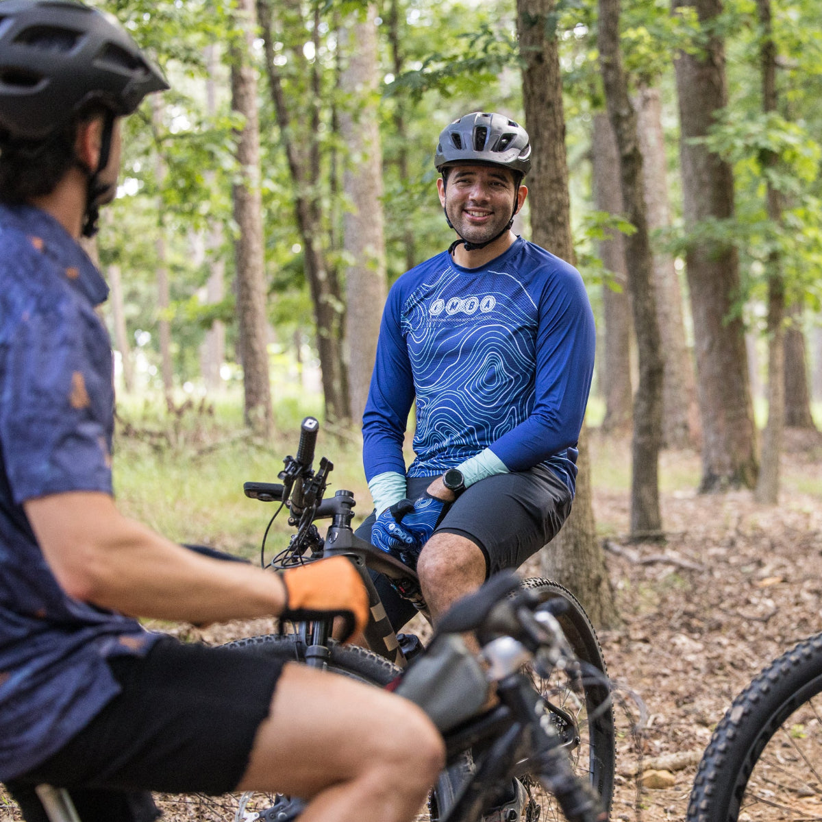 Three people on bicycles in a forest setting