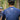 Two cyclists in a forest, one wearing a blue jersey with text on the back.