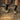 Person wearing hiking boots and socks on a trail with a bike in the background