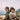 Two people sitting on a rocky outcrop with mountains in the background