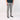 Person wearing gray jeans and black sneakers on a white background