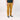 Person wearing mustard yellow pants and black sneakers on a white background