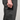 Close-up of a person wearing dark charcoal gray cargo pants, showing a hand reaching into a zippered side pocket to retrieve a black textured card or wallet.