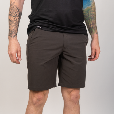 Person wearing dark shorts and a black shirt on a plain background