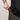 Person wearing a black shirt and brown pants against a light gray background