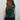 Person wearing a green tie-dye sleeveless shirt against a plain background