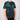 Person wearing a green and black tie-dye t-shirt with a brand logo on a plain background