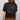 Person wearing a black tie-dye t-shirt with rust-like patterns on a plain background