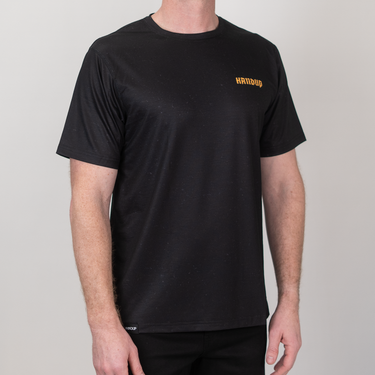 Person wearing a black t-shirt with yellow text on a plain background