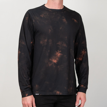A man wearing a black long-sleeve athletic shirt with a brown and orange tie-dye pattern, shown from the neck down against a light gray background.